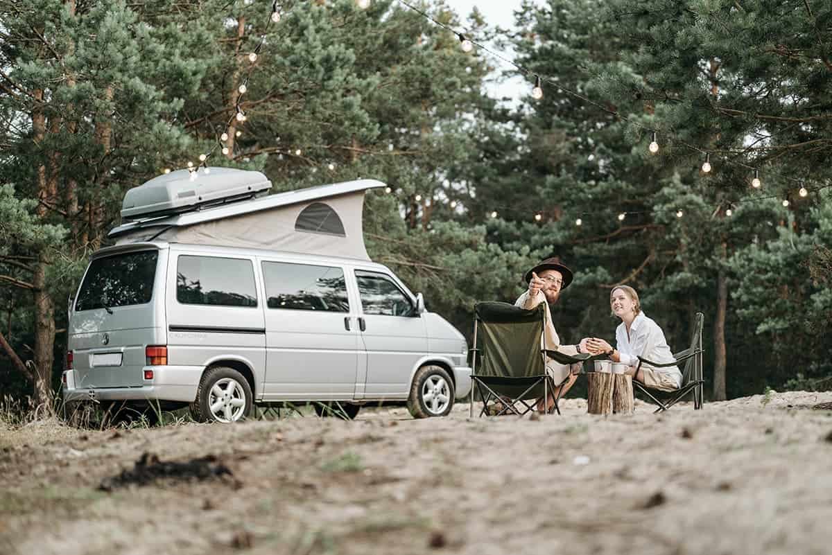 A campervan parked at a campsite among trees