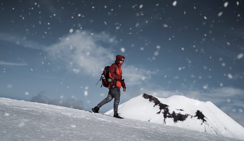 A hiker explores snowy slopes at Tongariro National Park, New Zealand.