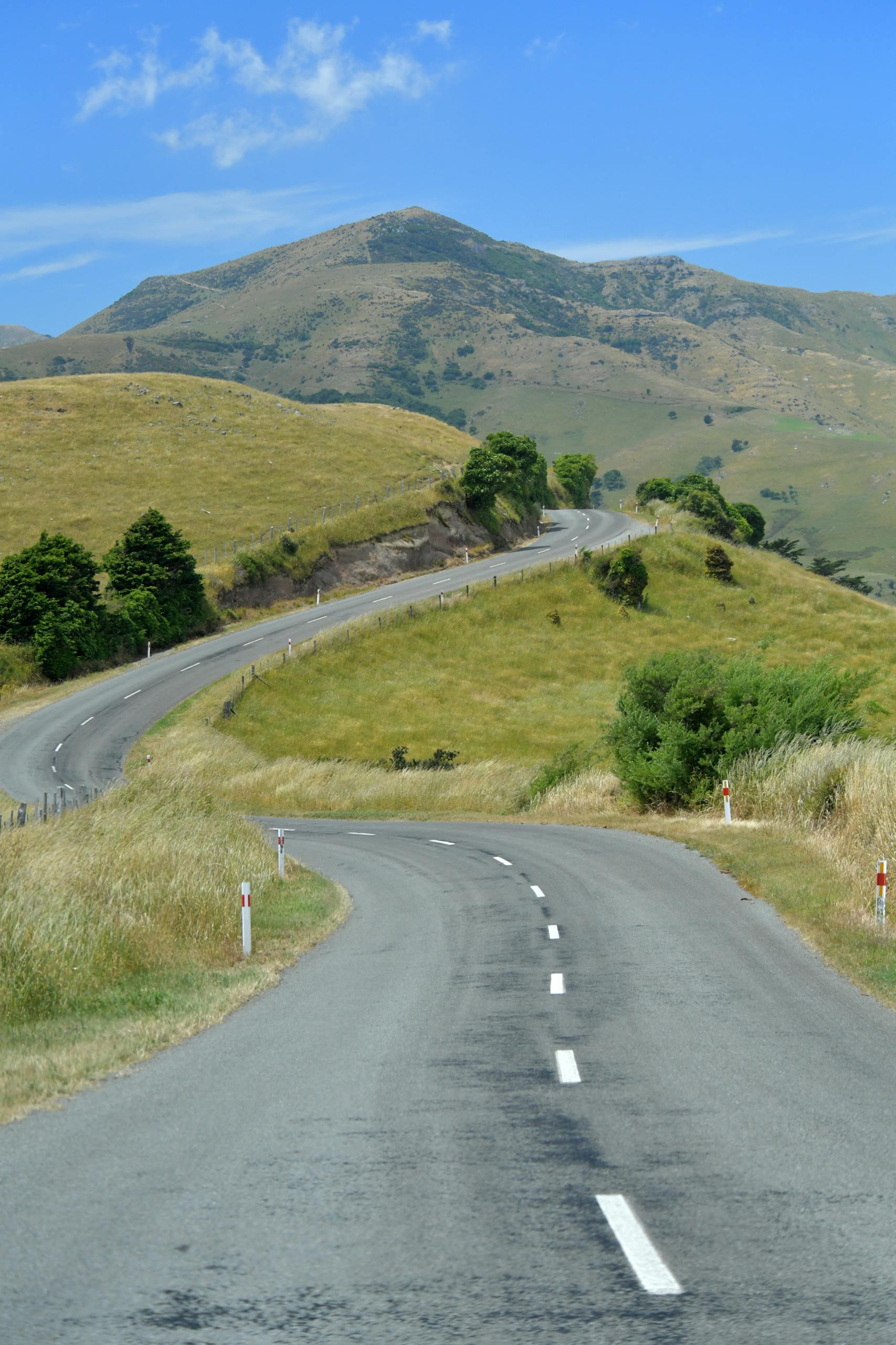 An empty road running through green hills